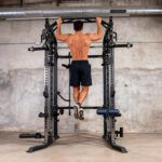 Domáca posilňovňa s lavičkou, kladkami a posilňovacou vežou.