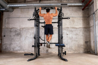 Domáca posilňovňa s lavičkou, kladkami a posilňovacou vežou.